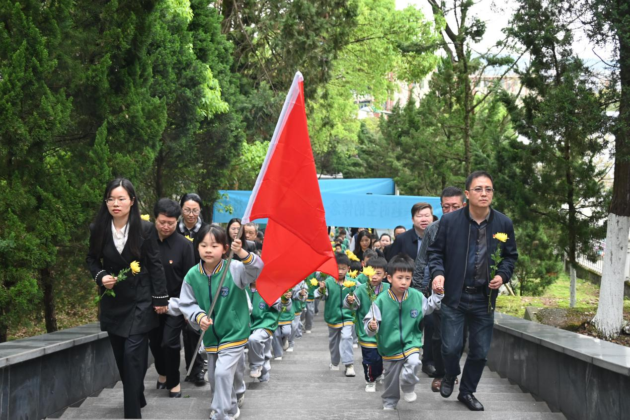 圖為志愿者們緩步走向革命烈士紀念碑.png