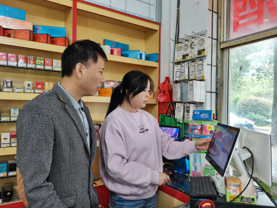 圖為吉安縣煙草專賣局客戶經理指導客戶使用終端系統