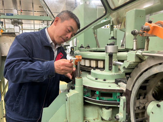 圖為該廠卷包車間副主任技師黃昕利用轉班時間調試設備