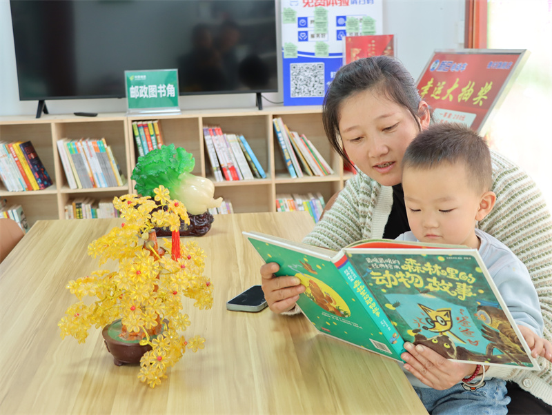 圖為村民帶著孩子在雪穎超市的圖書角讀書
