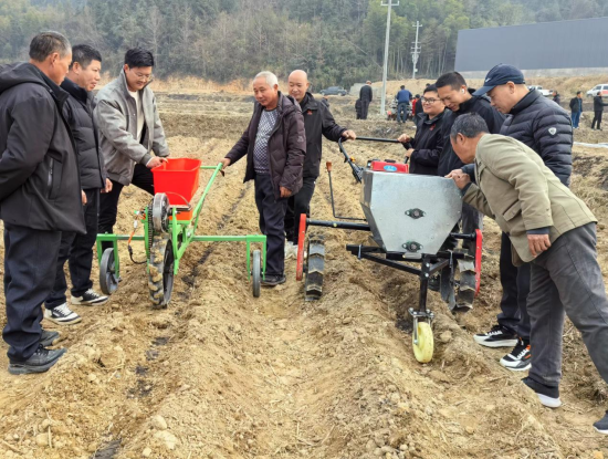 圖為煙農(nóng)施肥蓋膜現(xiàn)場會上觀摩施肥機(jī)