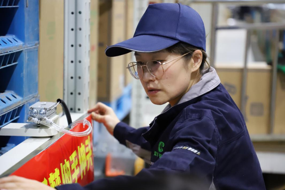 圖1 安全管理員趙青在作業現場粘貼警示標語  呼倫貝爾市局嶺西卷煙物流中心 姜騰交攝