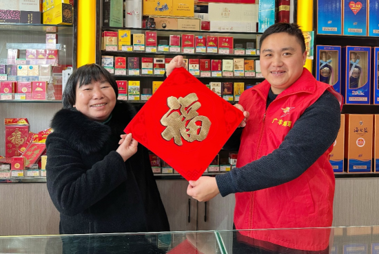圖為廣豐煙草志愿者為零售戶送福送裝飾