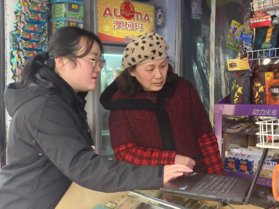圖為客戶經理丁茹指導零售戶使用現代終端系統