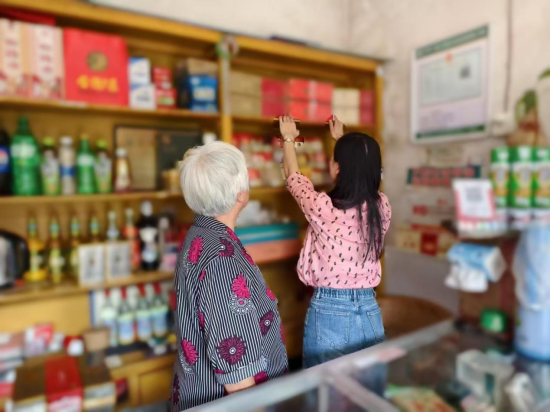 圖為客戶經理幫助老人美化店鋪