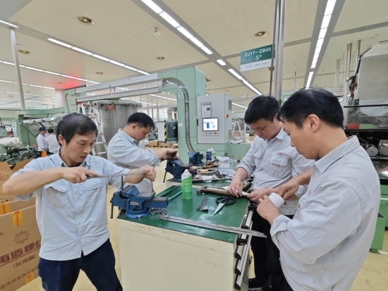 圖為該廠卷包車間維修工對卷煙機易損件進行調整