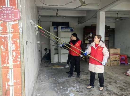 圖為武寧煙草組織志愿者幫助客戶店鋪刮墻刷白