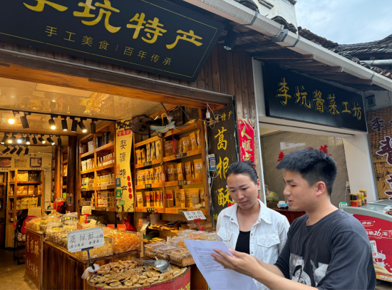 圖為專賣人員對景區商戶開展普法宣傳