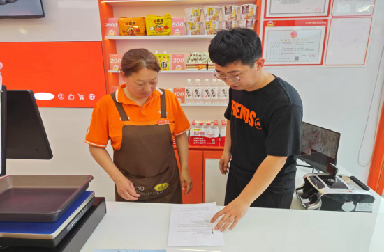 圖為工作人員向商戶發放宣傳手冊并講解違法后果.p