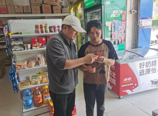 圖為客戶經(jīng)理指導(dǎo)零售戶使用手機(jī)線上反映問題