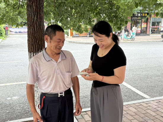 圖為店主任吉萍幫老人用智能手機線上充話費